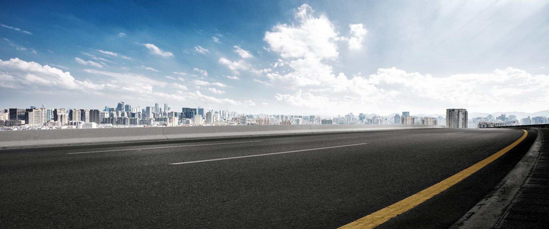 empty road and cityscape of modern city against cloud sky