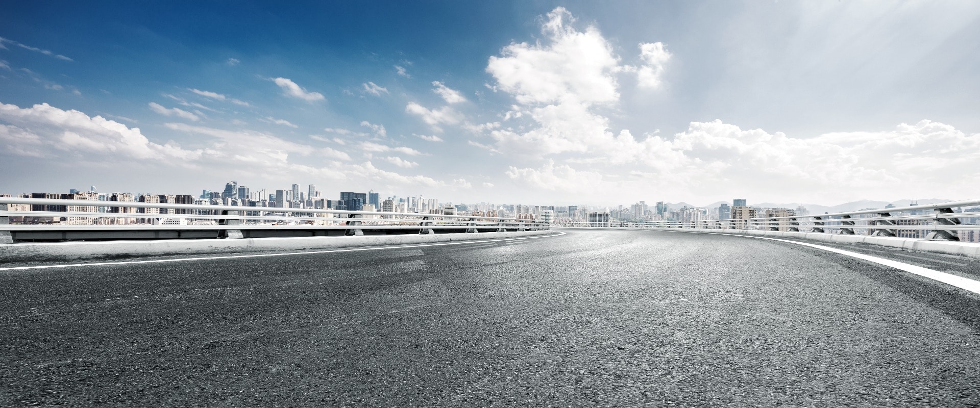 empty road and cityscape of modern city against cloud sky