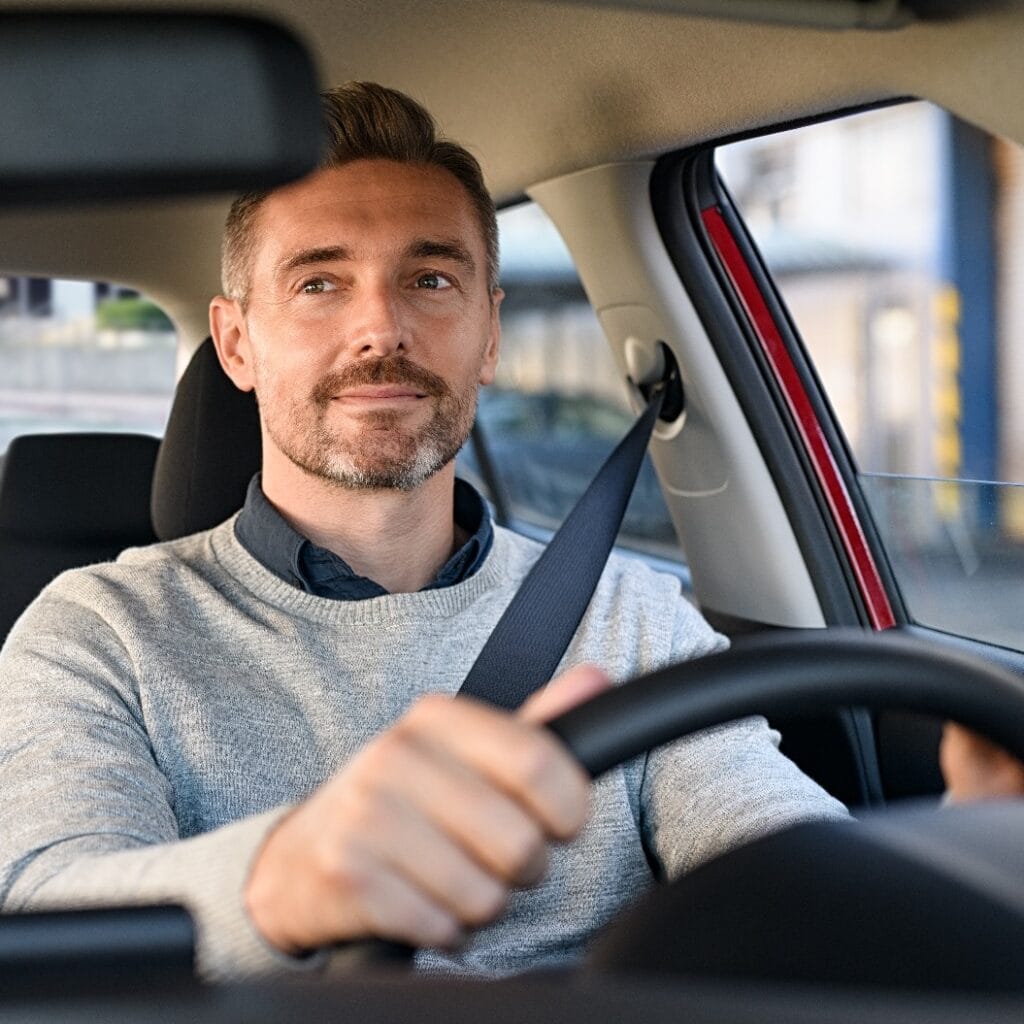 Glücklicher reifer Mann am Steuer eines Autos